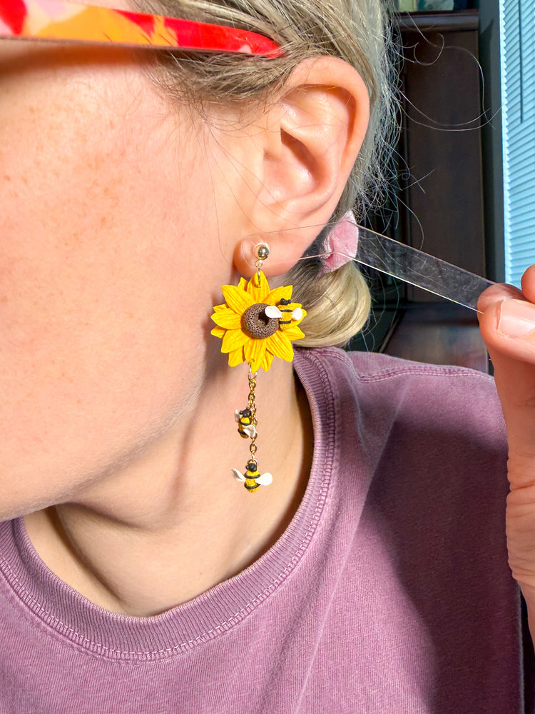 Try on picture of sunflower earrings with bees dropping from them