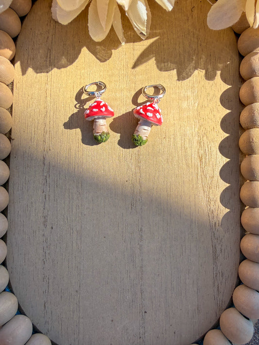 Pair of mushroom-shaped earrings on a wooden surface