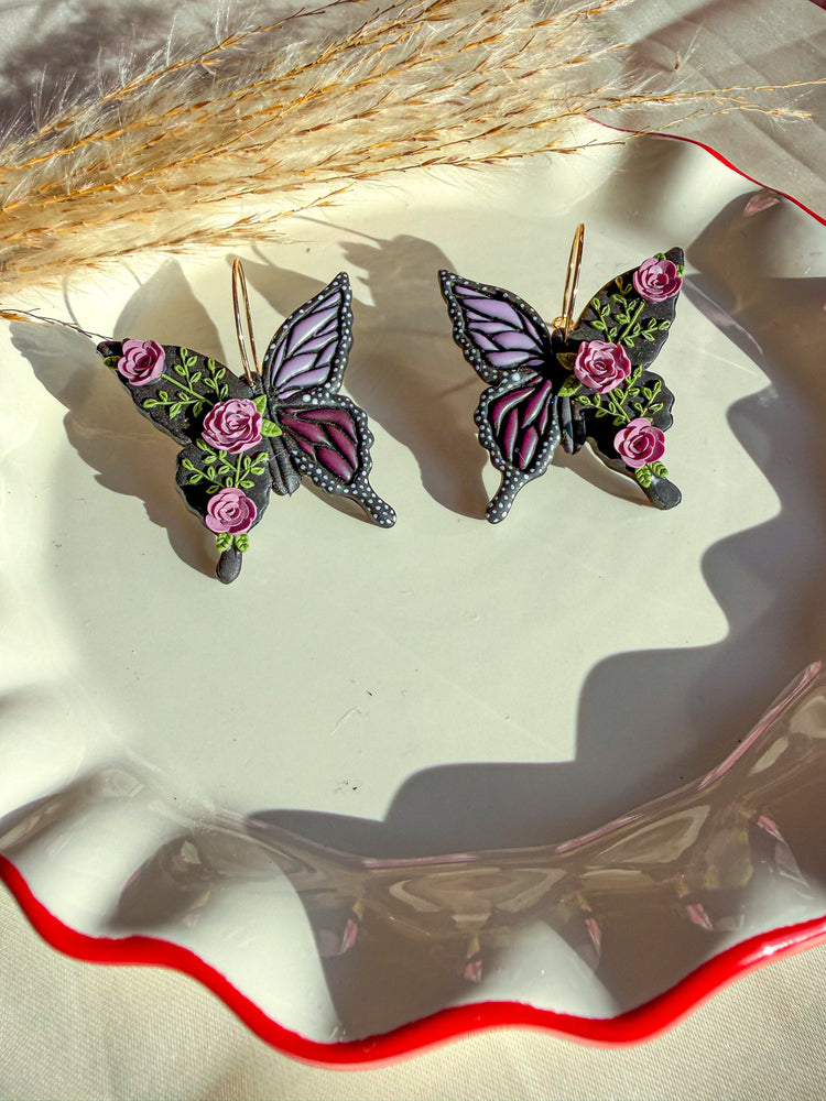 Black butterfly hoop earrings with purple flowers