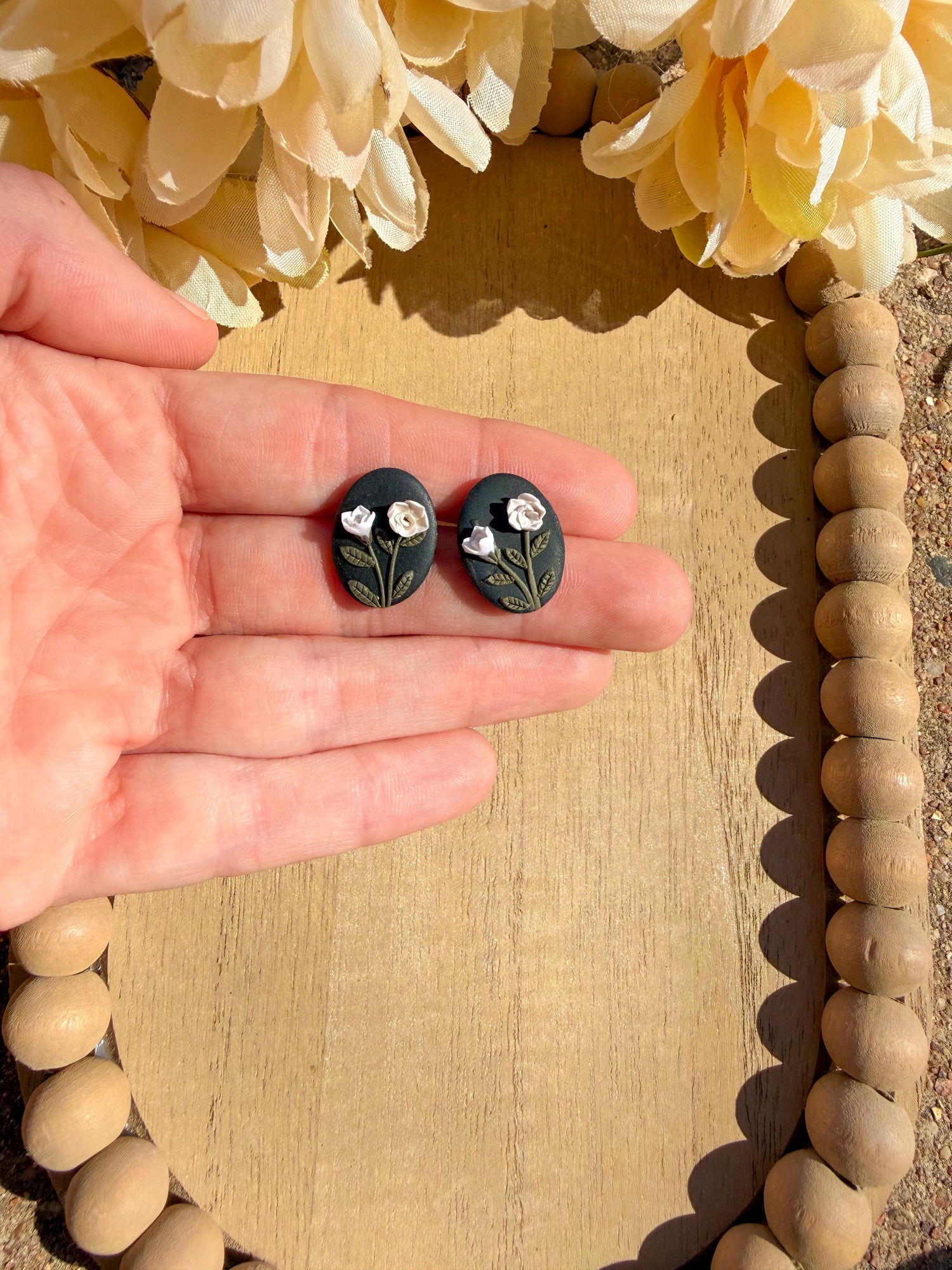 Black smaller stud earrings with neutral colored flowers