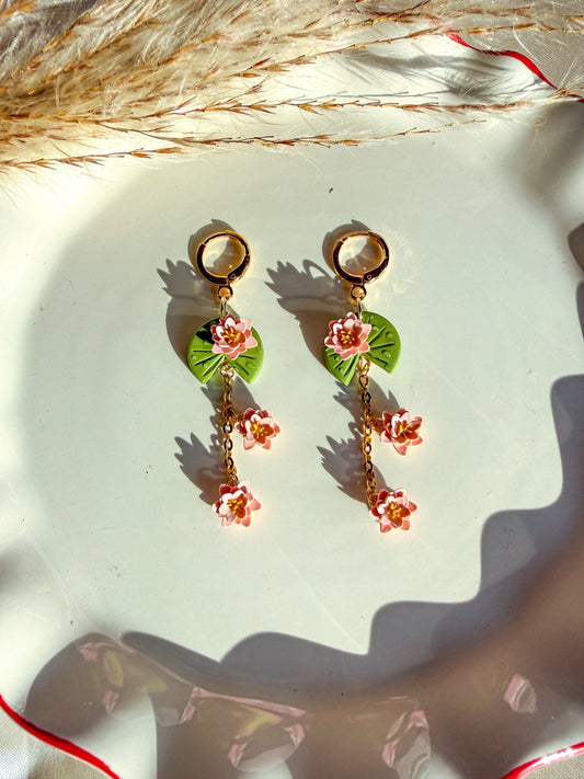 Floral lily pad earrings with pink flowers on a light background