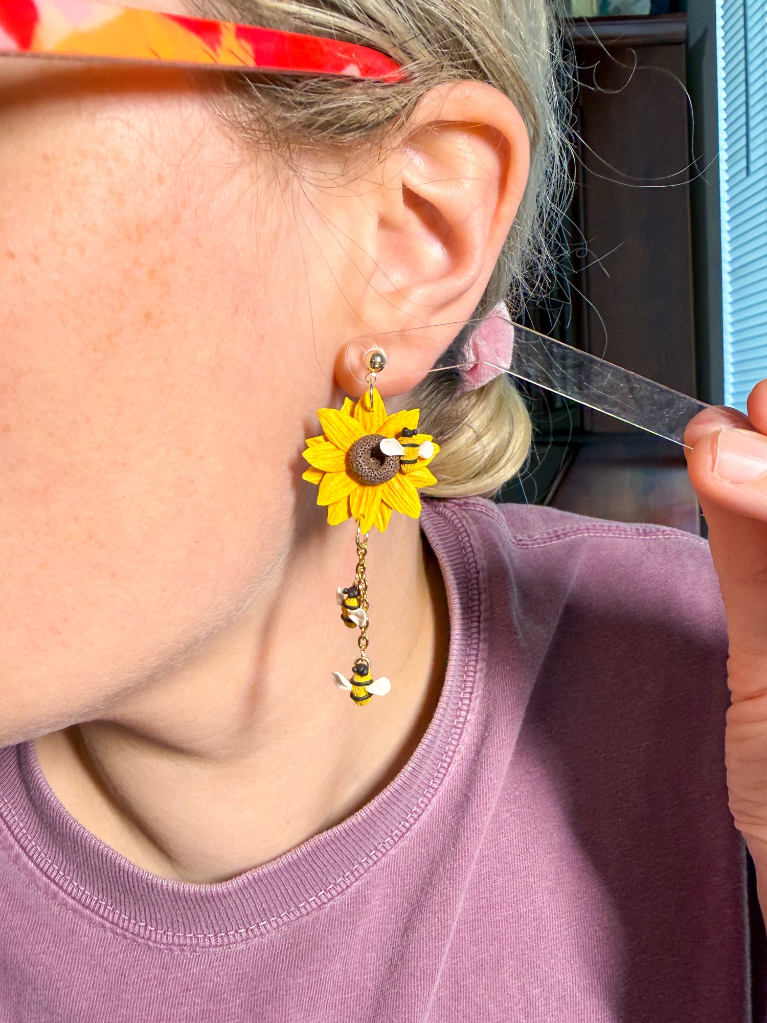 Try on picture of sunflower earrings with bees dropping from them