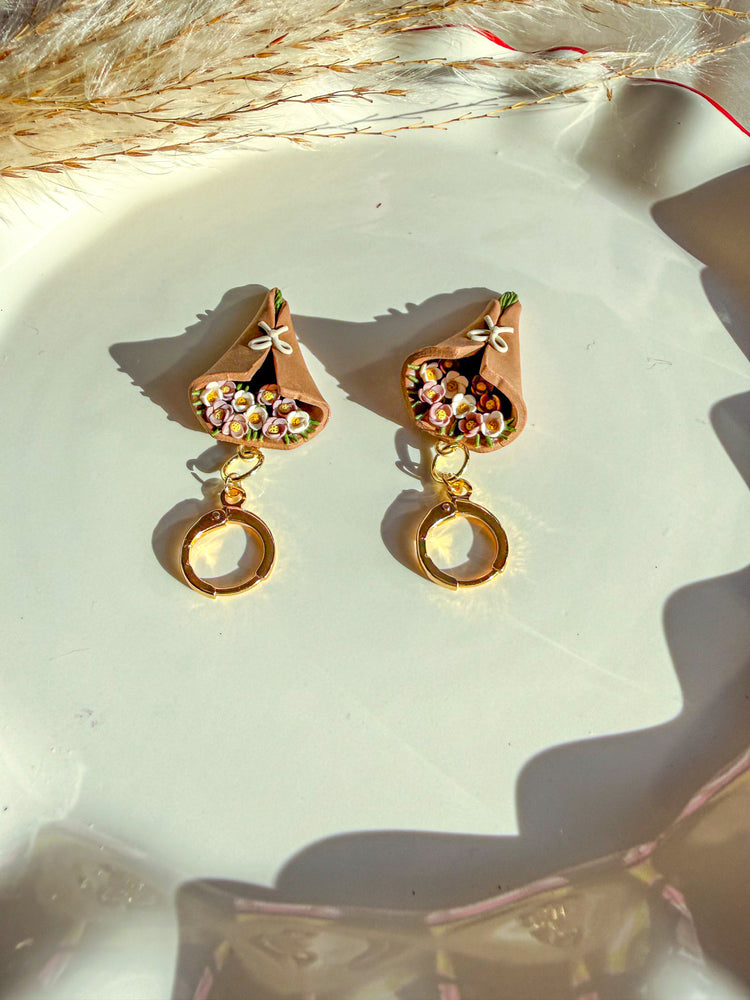 White and lilac colored flowers with green flower stems in flower brown bouquet earring