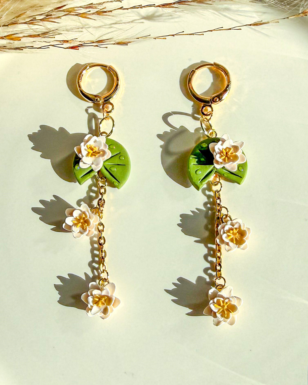 Pair of green lily pad flower earrings with white blossom flowers