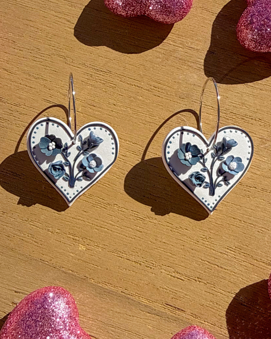 White heart dangle earrings with blue floral accents