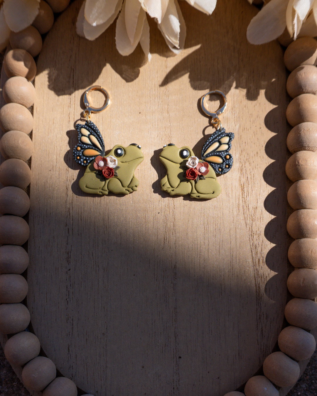 Polymer clay green frog earrings with monarch wings and rust colored flowers